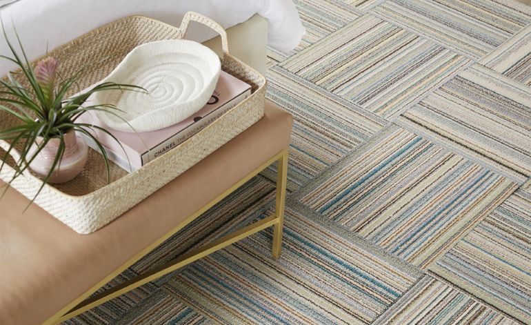 A bed with a basket and a plant, positioned on contemporary tile flooring, reflecting Miami, FL's interior design style.