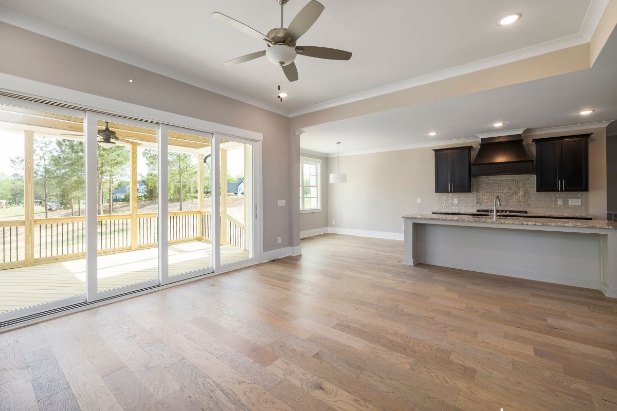 A spacious kitchen featuring hardwood floors and sliding glass doors, showcasing an elegant and luxurious design.