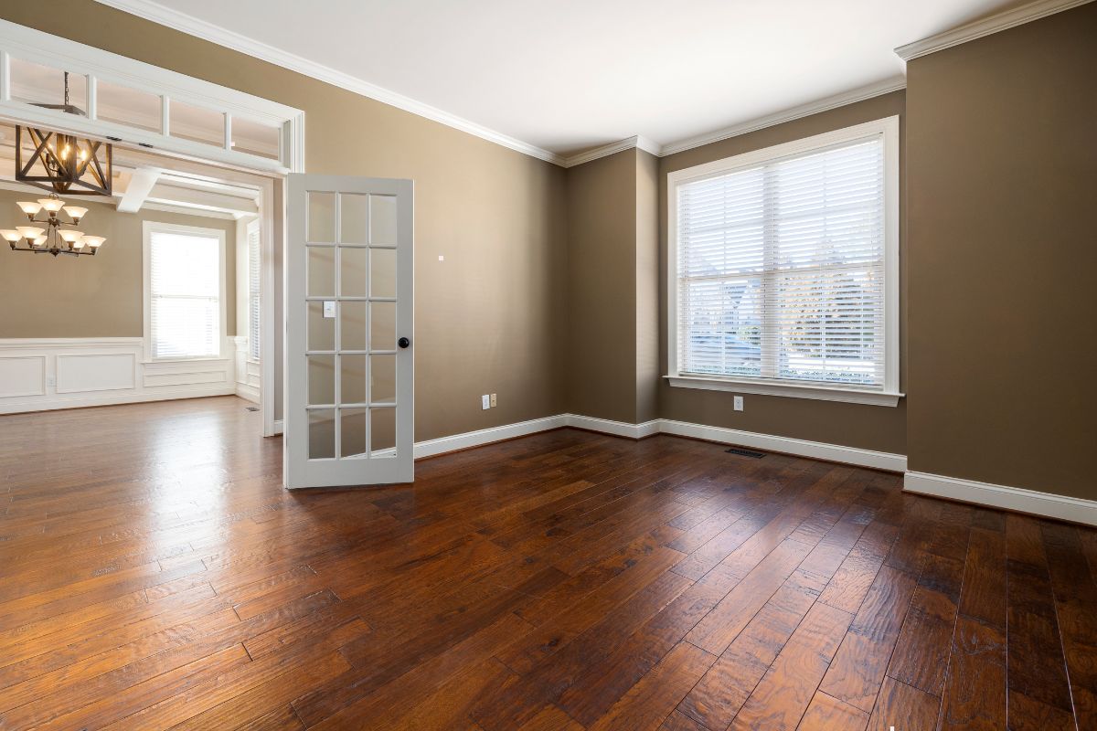 A stylish room with rich hardwood flooring and a door, reflecting luxury and refinement in its design.