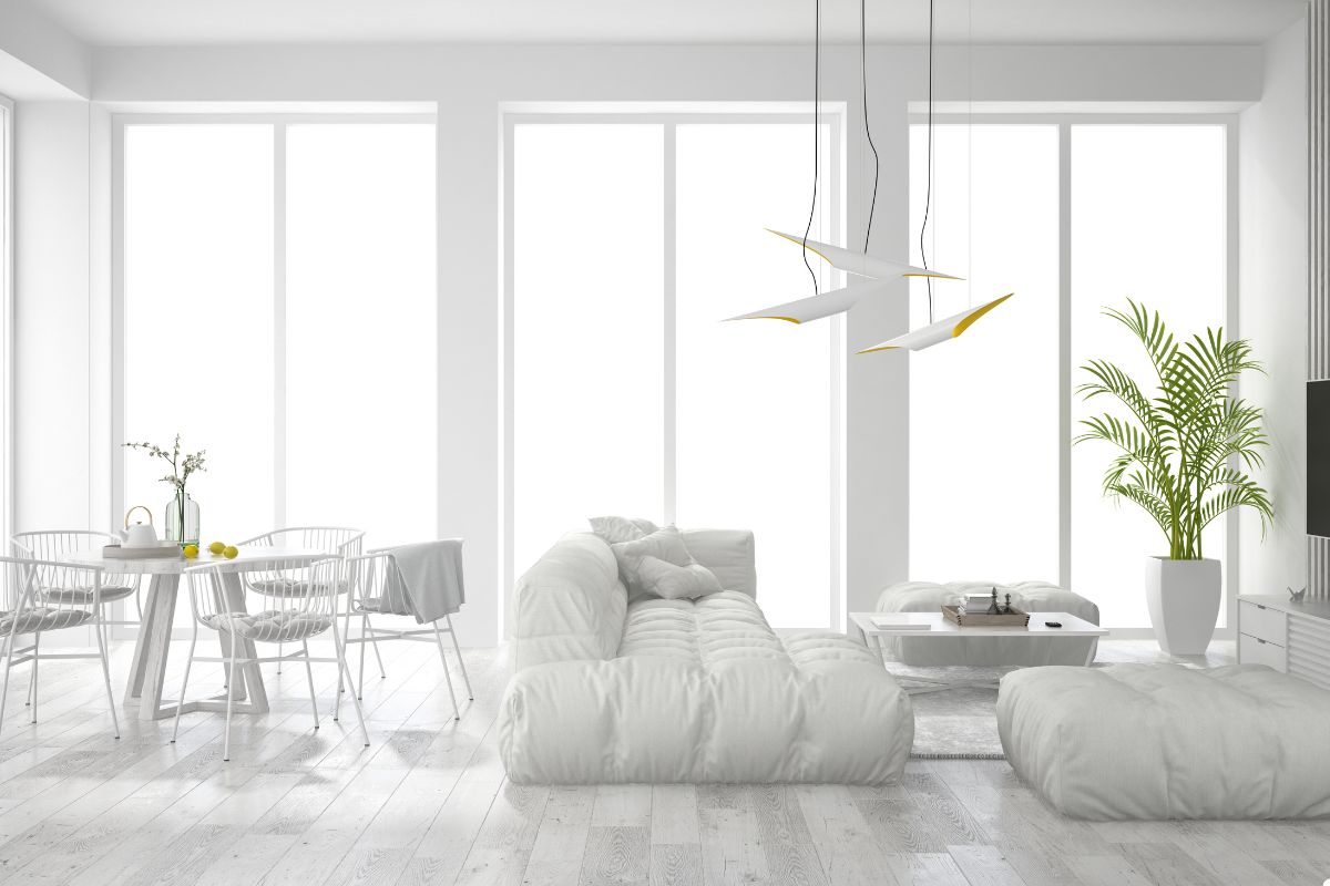 Contemporary white living room with a large window, creating an airy and inviting atmosphere.